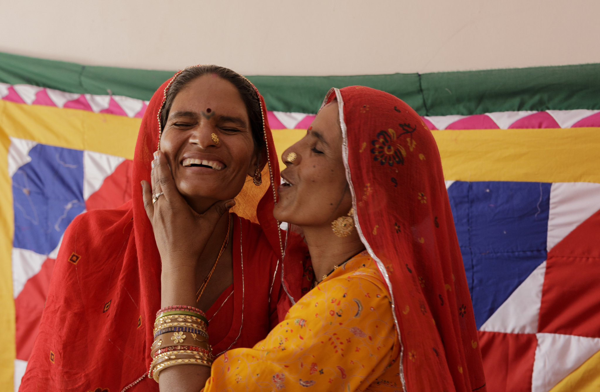 "Two Saheli Women artisans expressing love and support through a heartfelt kiss, symbolizing the bonds of solidarity and empowerment among women."