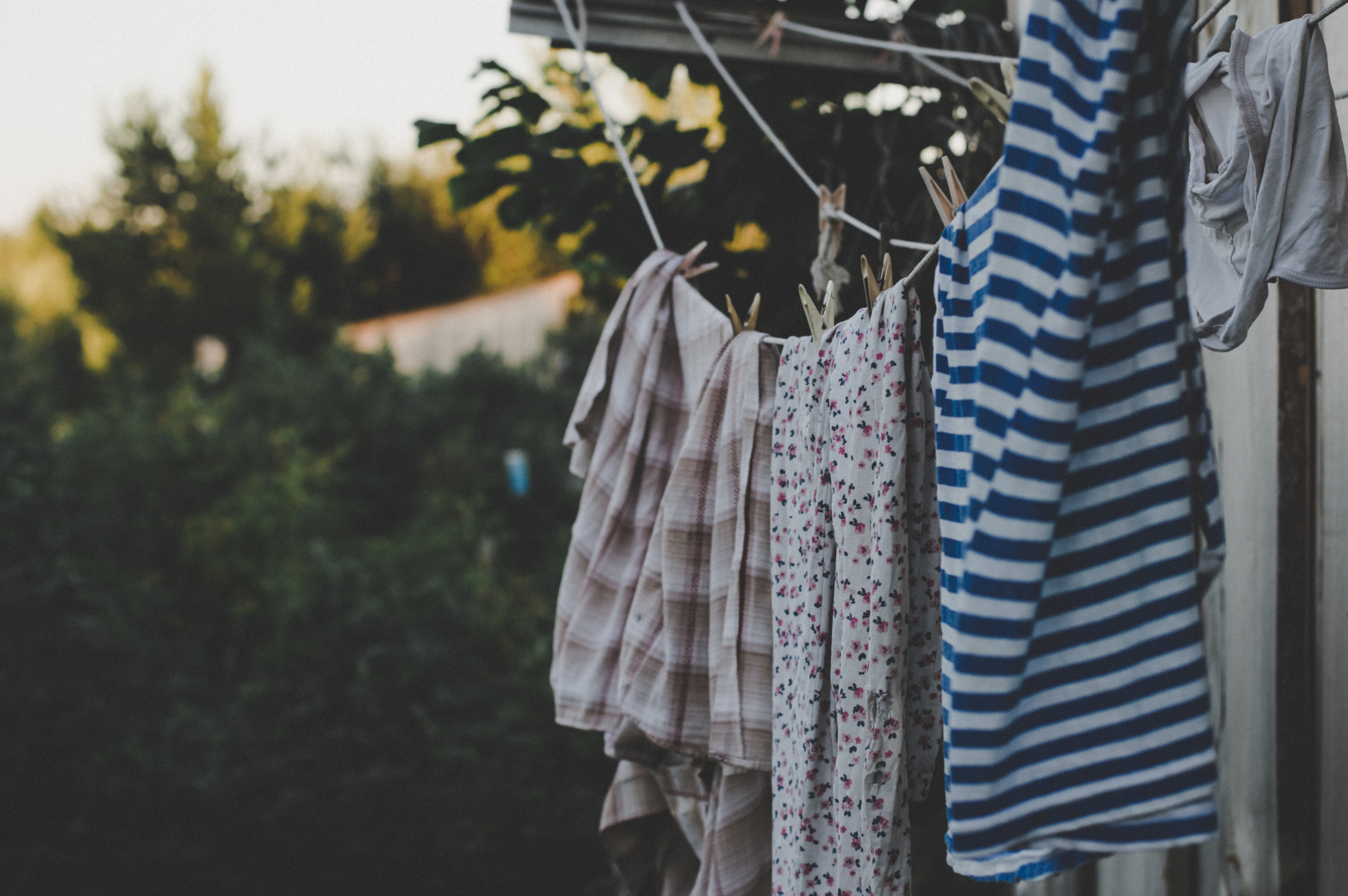 Colorful clothes hanging to dry outside, embracing eco-friendly laundry practices.